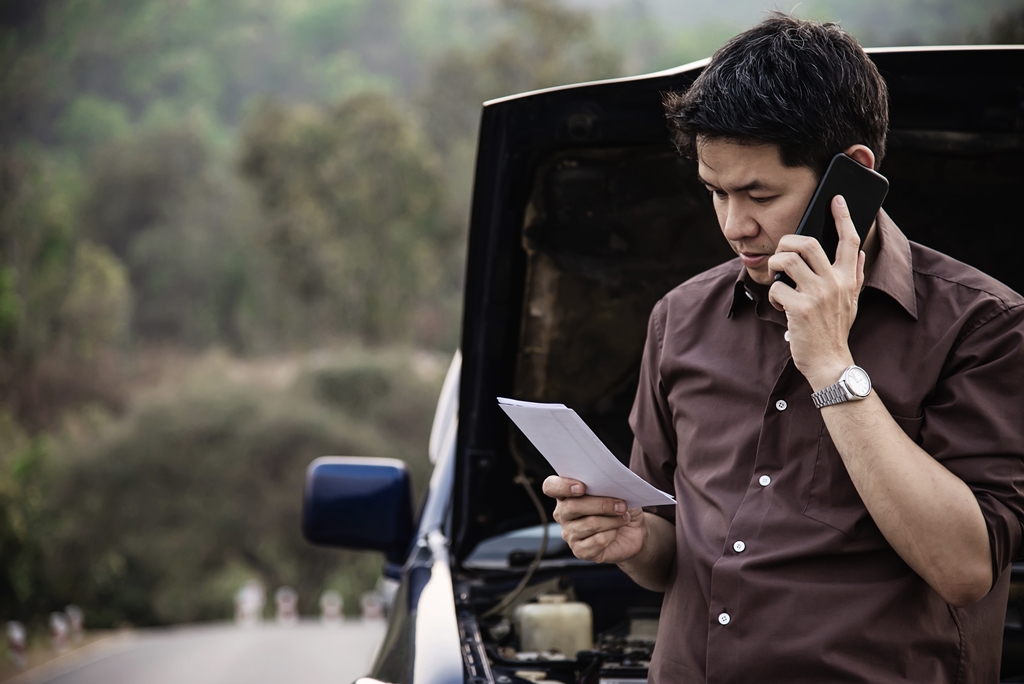 A man calling his insurance company to report his car accident