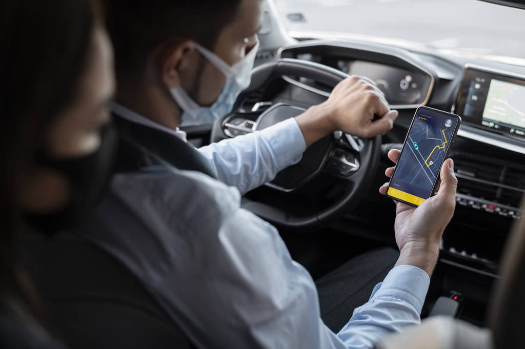 A person taking an e-hailing ride with the driver looking at a map via his phone