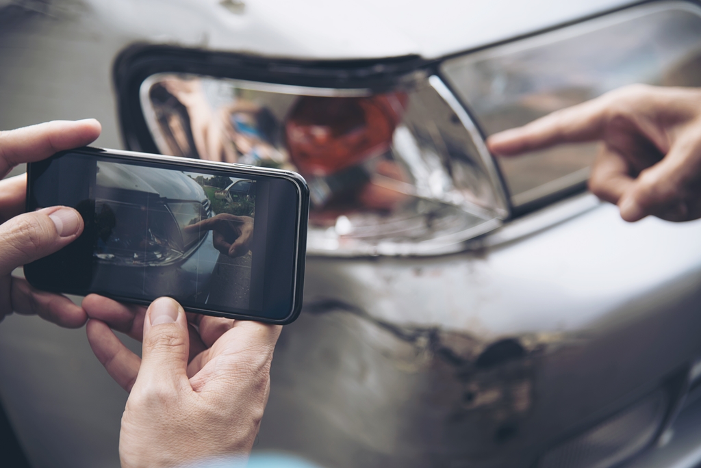 A person taking photos of damages to his car