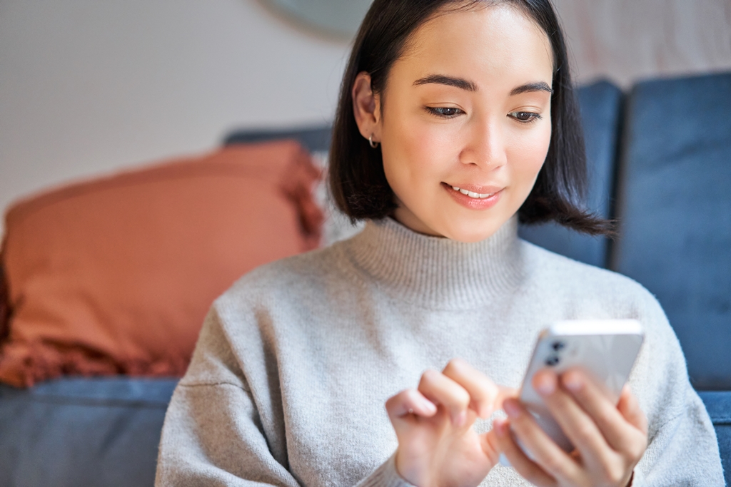 Woman types on her smartphone