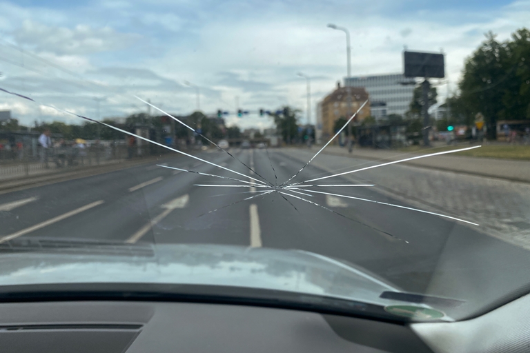 Crack on the windshield of a car, a trace of a stone on the road