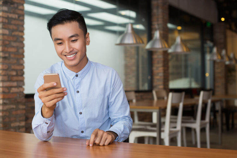 A man looking at his phone with a smile