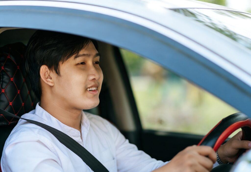 A man test-driving a new car to check its features before purchasing as a first-time car buyer.